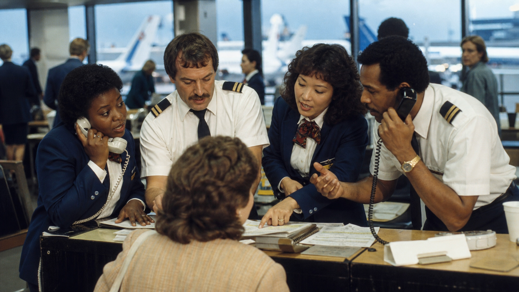 Frontline airline employees improvising together with warmth and urgency during a busy airport disruption